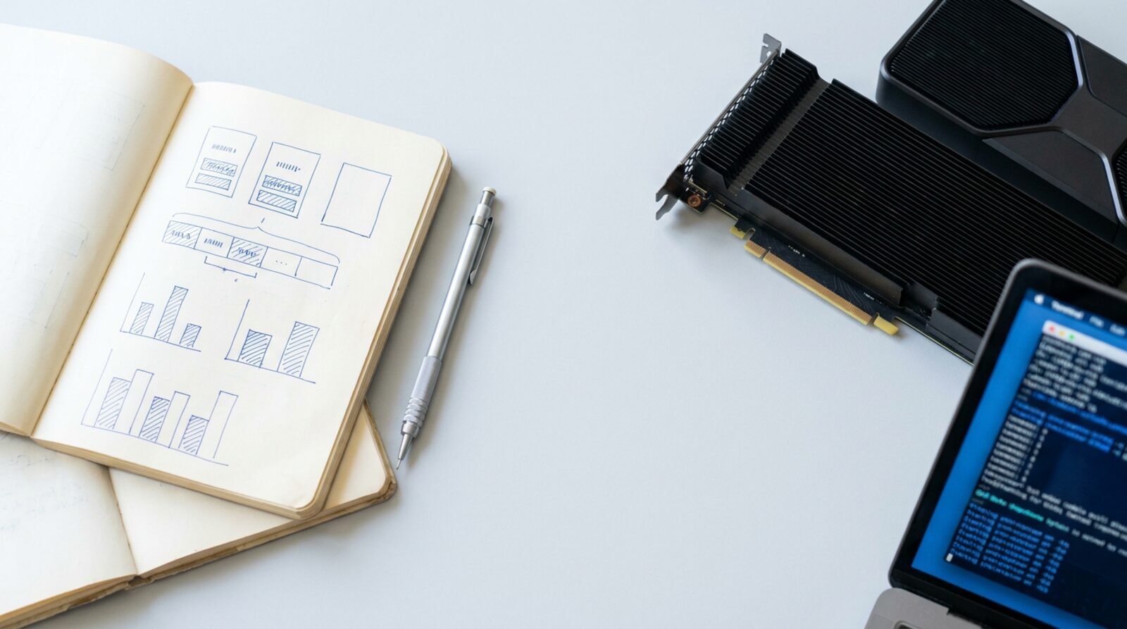 A notebook of memory diagrams beside a data-centre GPU card and a terminal.